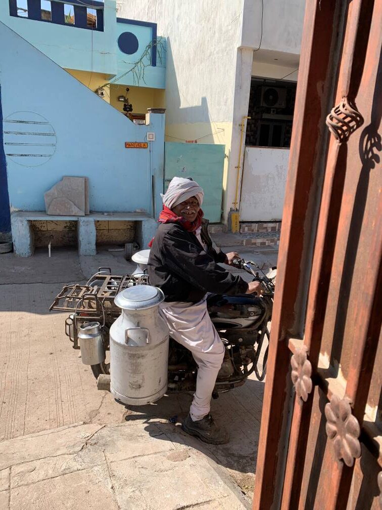 A milkman at the door brings us a big smile.